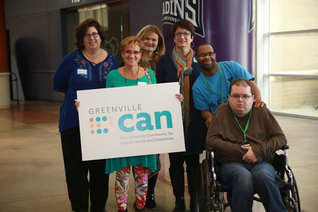 picture of people holding GCAN logo at an event.