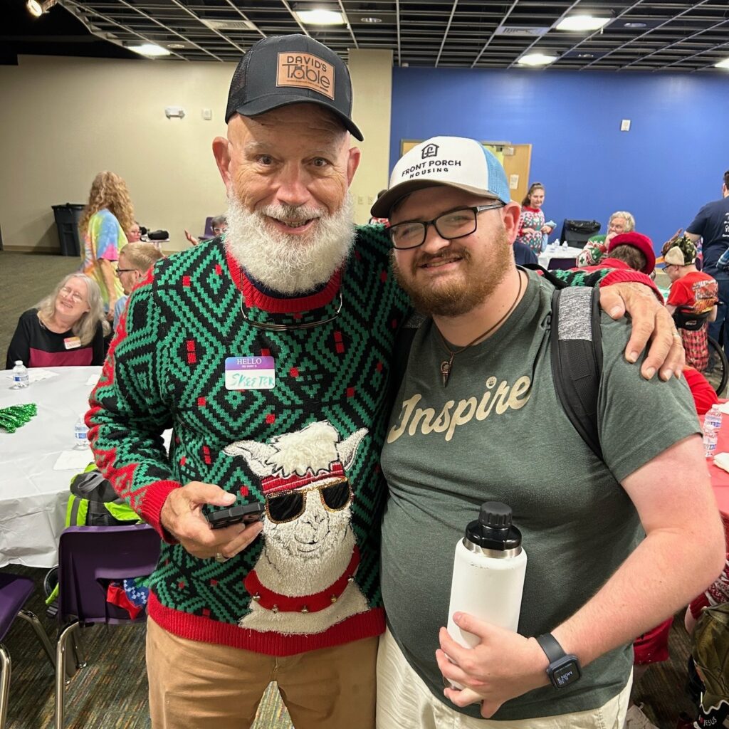 A man with a beard poses with a young man for the camera.