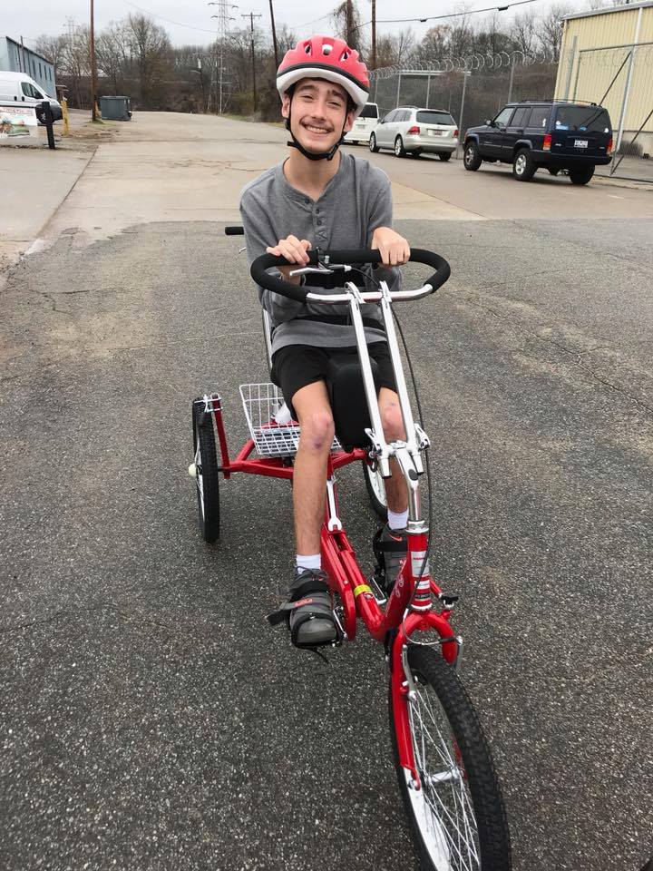 A young man rides a trike.