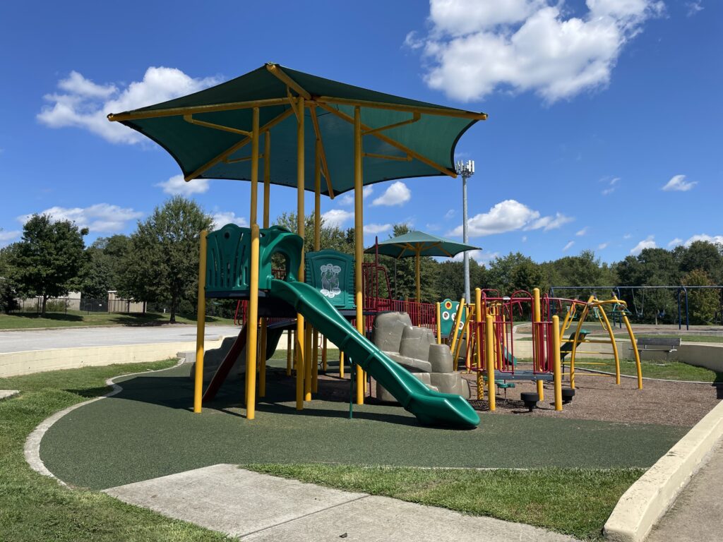 Inclusive playground set with slides, swings and shade.